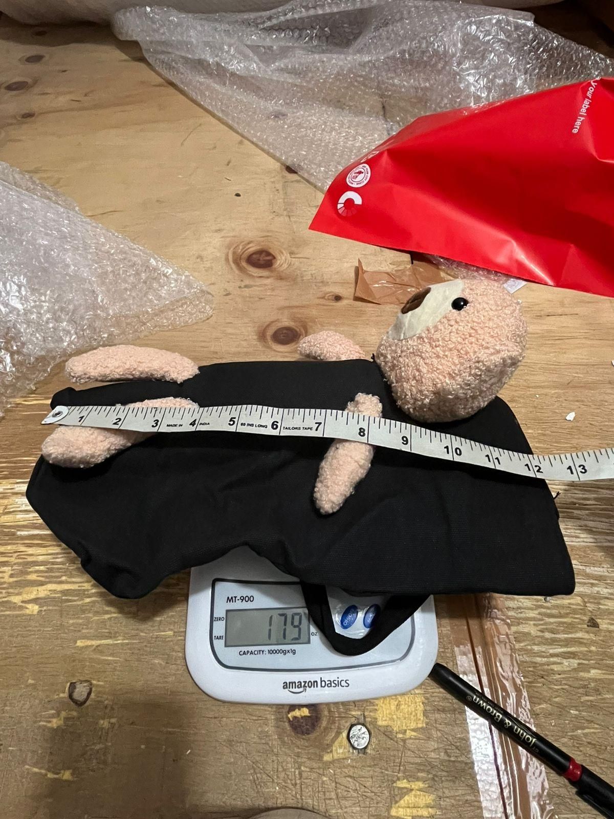 black cute shoulder bag with teddy bear plush on digital scale measuring 179 grams