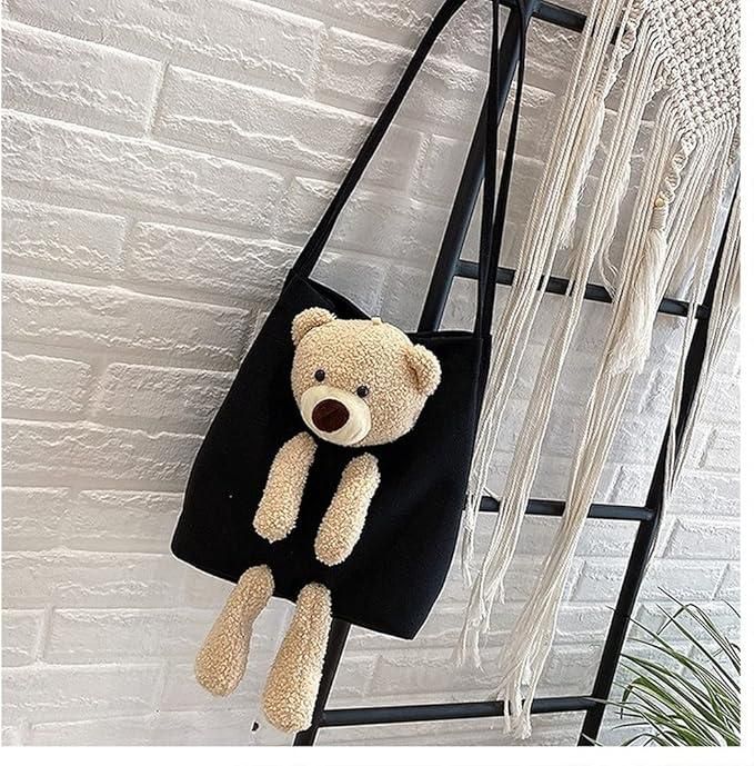 Black cute shoulder bag with plush teddy bear hanging on a ladder against a white brick wall background