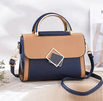 Stylish oblique crossbody women bag in navy and tan with gold accents and adjustable strap