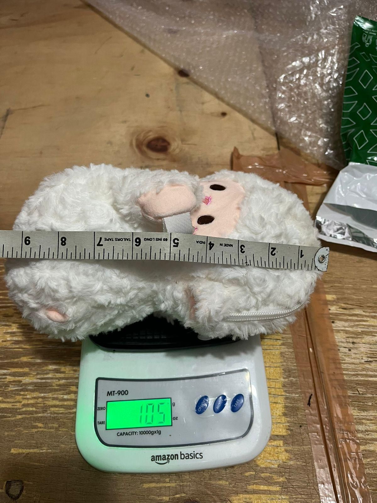Small cute lamb plush bag on a scale showing weight of 105 grams