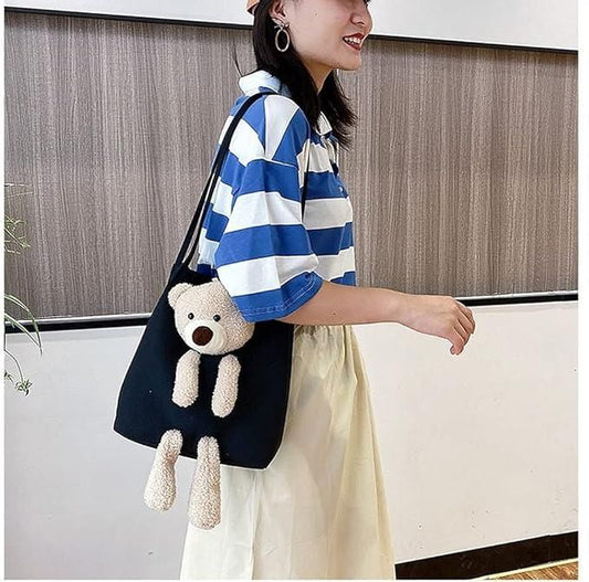 Woman carrying a black cute shoulder bag tote with a plush teddy bear attached