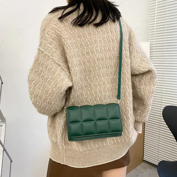 Green leather women shoulder bag with adjustable strap worn crossbody with beige sweater and brown skirt
